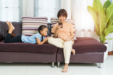 Happy Asian girl with sister play on the smart phone together at home