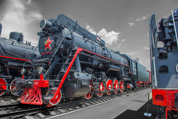 Heavy powerful Sovetsky Steam locomotive. Colored steam locomotive on a black and white background.