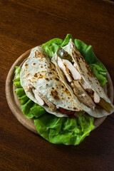 Fajitas Tortilla with chicken, sweet peppers and onions. Wood background. detail