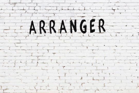 White wall with black paint inscription arranger on it