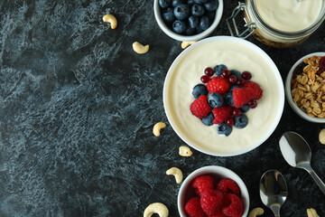 Concept of tasty breakfast with yogurt on black smokey table