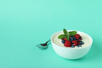 Concept of tasty breakfast with yogurt on mint background