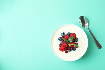 Concept of tasty breakfast with yogurt on mint background