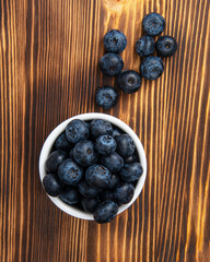 Fresh blueberry in white dish on wooden background