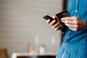 Mid aged casual man holding mobile phone