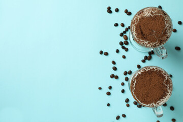 Glasses of irish coffee and coffee seeds on blue background