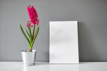 Blank canvas and flower on white table on gray wall background