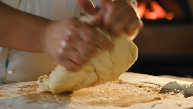 Cooking pizza. Delicious Italian food. The cook kneads the pizza dough. Cooking pizza in the oven. A man kneads yeast dough with his hands.