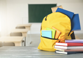 School backpack with books on desk in classroom