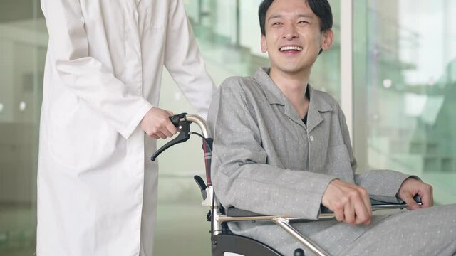 車椅子に乗った患者を励ます医師