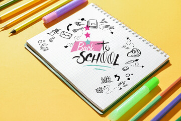 Set of stationery and notebook with text BACK TO SCHOOL on color background