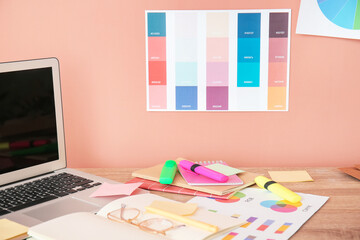 Stylish workplace of graphic designer with laptop in office