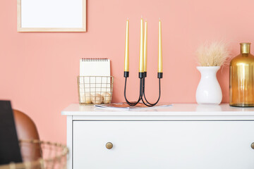 Aroma candles and decor on chest of drawers in room