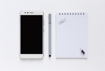Flat lay with notebook, phone, pencil on white background. Business office or planning concept. Copy space for text.