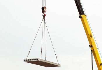 The building crane lifting the concrete plate