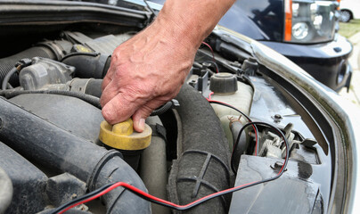 Fototapeta premium The man unscrews the oil cap on the car's engine.