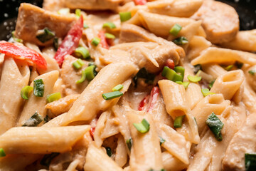 Frying pan with tasty cajun chicken pasta, closeup