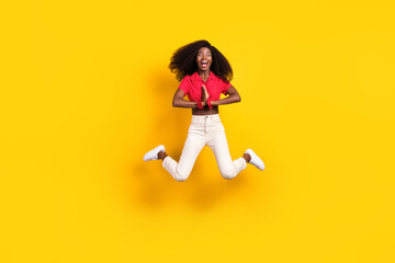 Fototapeta na wymiar Full length photo of happy dark skin young woman clap hands excited jump up isolated on yellow color background