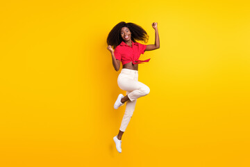 Fototapeta na wymiar Full size photo of young funky excited crazy girl jumping raise fists in victory success isolated on yellow color background
