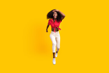Fototapeta na wymiar Full body photo of charming happy dark skin brunette woman look forward runner jump up isolated on yellow color background