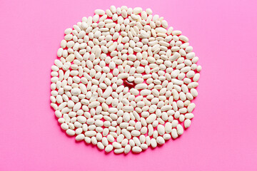 Red bean among white ones on color background. Concept of uniqueness