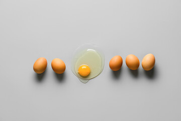 Fototapeta Broken egg among whole ones on grey background. Concept of uniqueness obraz