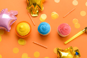 Composition with tasty Birthday cupcakes, balloons and candles on color background