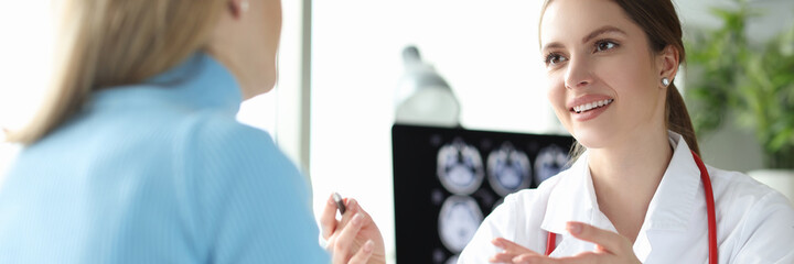 Pregnant woman at doctor appointment holding digital tablet with ultrasound image of fetus