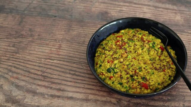 vegan golden savoury oats with bell pepper chickpeas and spinach topped with fla seeds, healthy plant-based food