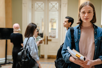 Young european students standing in library hallway