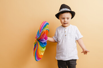 White boy with down syndrome in hat posing with toy