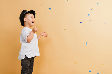 White boy with down syndrome in hat playing with confetti