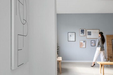 Woman at exhibition in modern art gallery