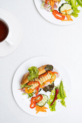 Banh mi sandwiches with various stuffing and cup of tea. Traditional vietnamese breakfast. Trendy still life in light colors, top view, copy space.