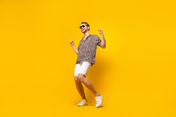 Full length photo of attractive cute gentleman dressed print shirt dark glasses dancing smiling isolated yellow color background