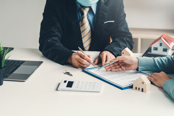 Real estate agents and clients deal in the sale of houses the contract was signed at the office.