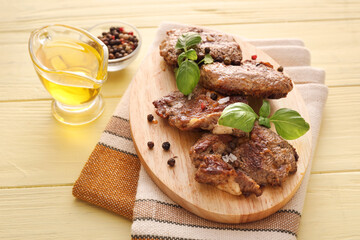Wooden board with tasty beef steaks on color wooden background
