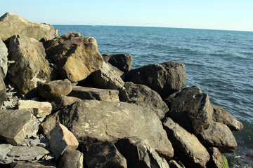 A rocky beach on a sunny day. Rocky seashore. The coastline.
