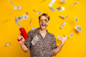 Photo of handsome rude gentleman dressed shirt dark glasses shooting money gun showing rock sign...