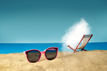 Fototapeta na wymiar Pink glasses on the sand close up. Glasses on a beach chair background. Beach chairs on a background of blue water and sky. White cloud sunbathes on the beach.
