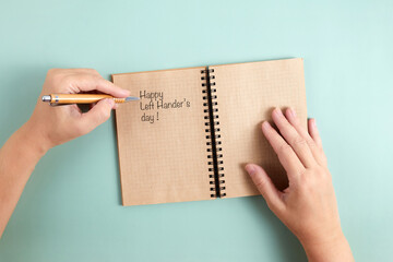 Happy Left Hander's Day. Left hand hold pen and writing text.