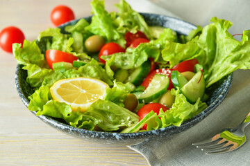 Plate of delicious fresh salad with vegetables on wooden table, closeup