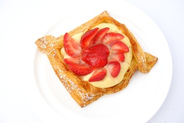 bread, delicious croissant on sweet red strawberries isolated on white plate background