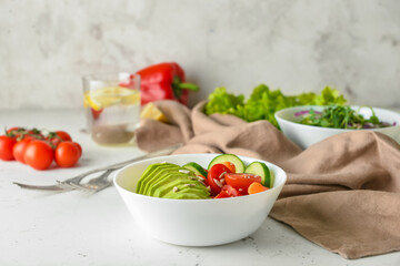 Bowl of delicious vegetables and seeds on light background