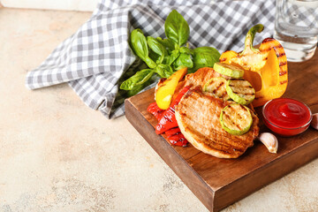 Board with tasty grilled vegetables and steaks on light background
