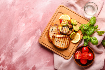 Board with tasty grilled vegetables and steaks on color background