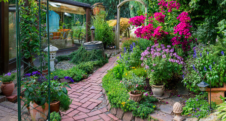 Fototapeta na wymiar Garten mit vielen blühenden Topfpflanzen und Weg im Sommer