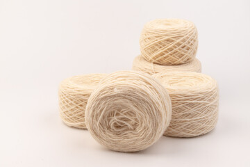 balls of light woolen thread on white background. natural wool. knitting. background
