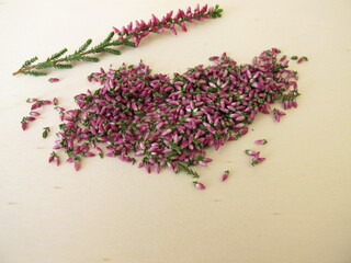 Obraz na płótnie Canvas Dried pink heather flowers on a wooden board