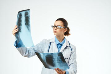 a radiologist in a white coat examines x-rays treating a patient